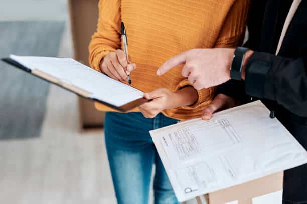 cropped shot of a woman signing for a delivery received at home